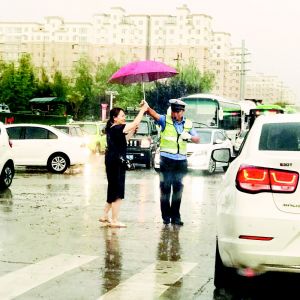 市民为雨中执勤交警送伞